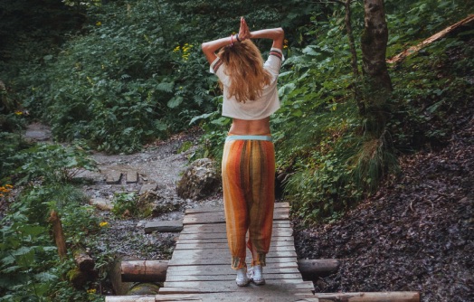 femme de dos marchant sur un sentier naturel