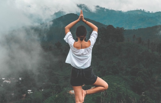 position de yoga de l'arbre devant un paysage apaisant