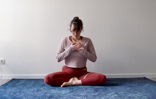 position assise, les mains jointes au coeur