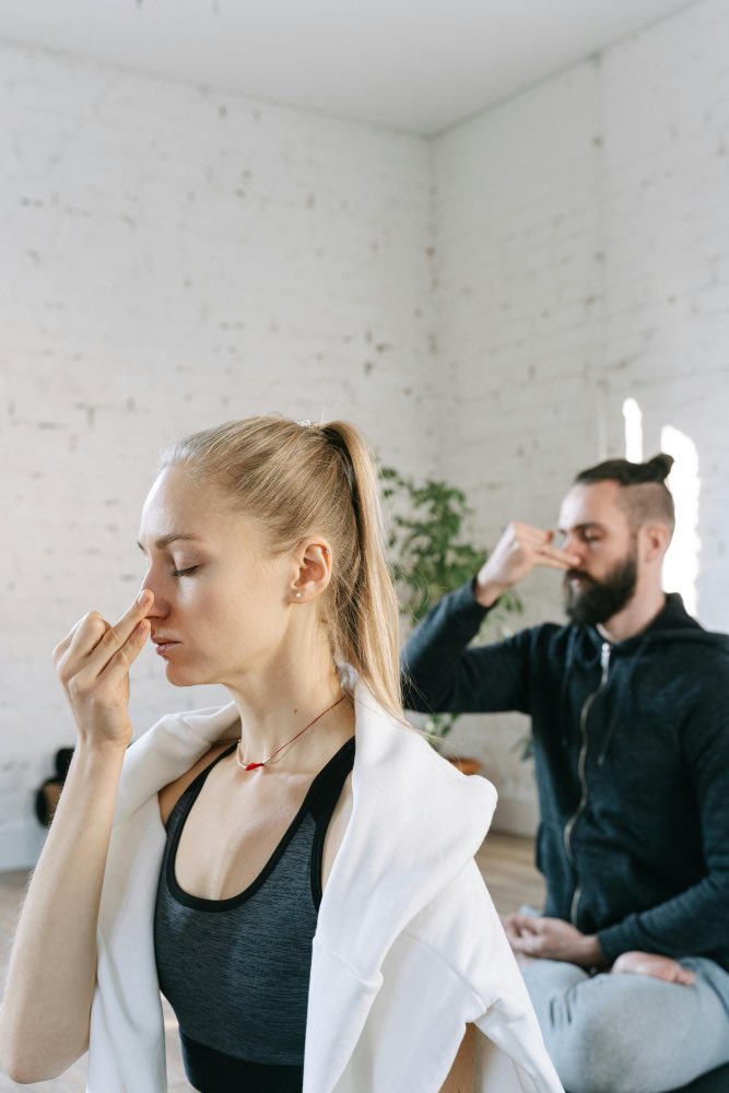 deux personnes en train de pratiquer le pranayama Nadi Shodhana