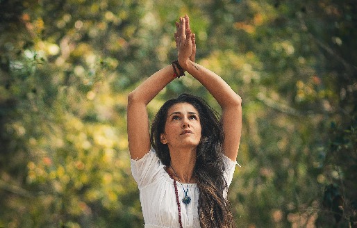 personne dans une position de yoga, les mains ensemble vers le ciel